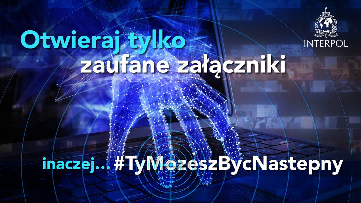 Napis: Otwieraj tylko zaufane załączniki inaczej...#TyMozeszBycNastepny. Z prawej strony widoczne jest logo Interpolu, w tle wychodząca z ekranu laptopa dłoń, która prawie sięga klawiatury i celownik