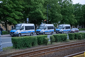 Przy drodze na wysokości stadionu stoją trzy policyjne radiowozy