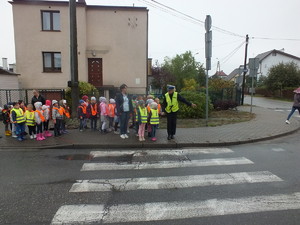 Policjantka wchodzi na przejście z uczniami