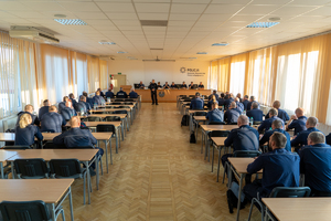 Widok na całą salę konferencyjna z policjantami siedzącymi w ławkach