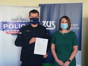 Policjant i Pani Dyrektor ZUS z ulotką.