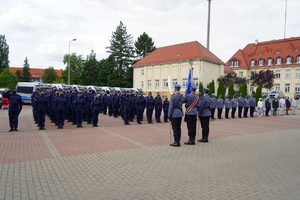 poczet sztandarowy stoi przed policjantami stojącymi w szeregu