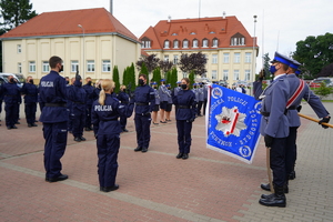 policjanci oddają honor przed pocztem sztandarowym