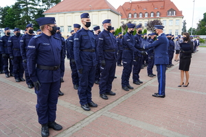 Komendant Wojewódzki gratuluje i przekazuje teczkę policjantowi
