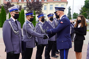 Komendant Wojewódzki gratuluje i przekazuje teczkę policjantowi
