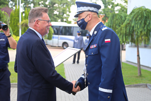 Komendant policji odbiera gratulacje od wicemarszałka województwa.