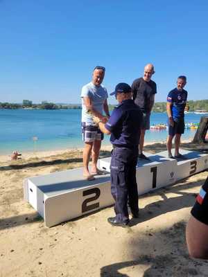 Policjanci na podium zawodów pływackich.