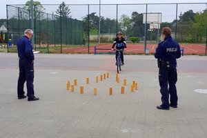 policjanci oceniają dziecko, które pokonuje na rowerze przeszkody