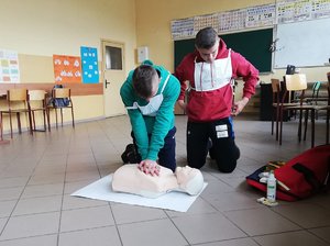 Sala gimnastyczna. Zawodnicy prowadzą resuscytację krążeniowo-oddechową na fantomie.