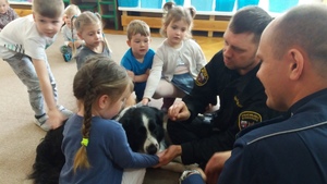 Sala przedszkolna. Policjant i Strażnik Miejski rozmawiają z dziećmi.