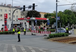 Skrzyżowanie ulic przy stadionie. Policjanci ruchu drogowego kierują ruchem pojazdów.