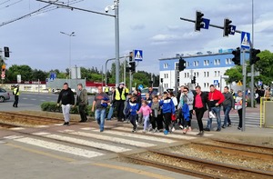 Skrzyżowanie ulic przy stadionie. Policjanci ruchu drogowego dbają o bezpieczeństwo kibiców na przejściach dla pieszych.