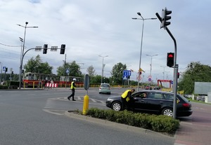 Skrzyżowanie ulic przy stadionie. Policjanci ruchu drogowego dbają o bezpieczeństwo kierując ruchem pojazdów.