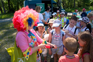 klaun pompuje balony i rozdaje je dzieciom