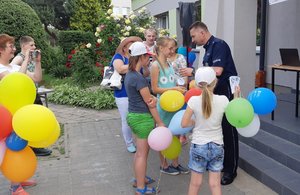 Policjant rozdaje dzieciom upominki.