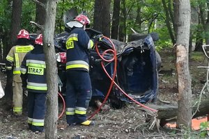 strażacy rozcinają przewrócony samochód