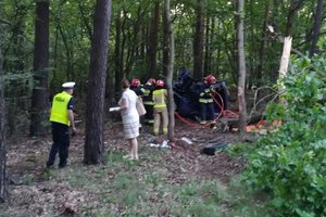 strażacy rozcinają przewrócone auto