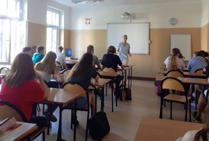 Profilaktyk policyjny podczas zajęć z uczniami w sali szkolnej.