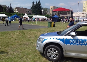 Policjanci z radiowozem podczas festynu.