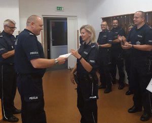 I Zastępca Komendanta Miejskiego Policji w Bydgoszczy mł. insp. Przemysław Mielczarek wręcza dyplom zwyciężczyni. W tle inni uczestnicy konkursu.