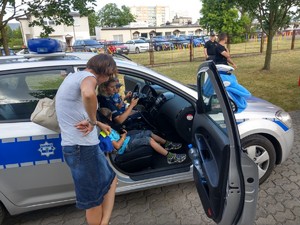 Uczestnicy festynu oglądają radiowóz.