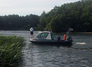 Patrol akwenu policyjną łodzią motorową wraz z przedstawicielami innych służb.