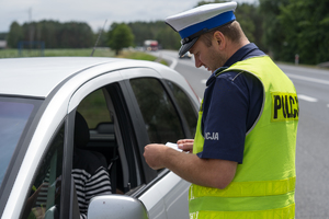 policjant kontroluje dokumenty kierowcy