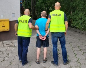 Policjanci prowadzą zatrzymanego.