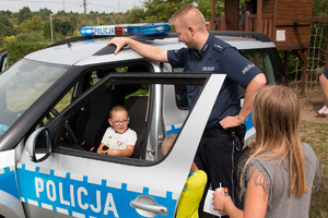 Dzielnicowi prezentują dzieciom radiowóz.