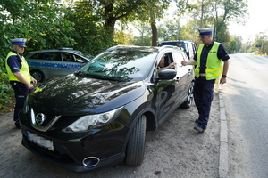 Policjanci podczas akcji kontrolują pojazd.