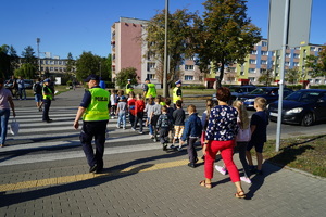 Dzieci i policjanci na przejściu dla pieszych.