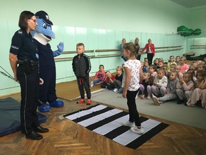 policjantka tłumaczy dzieciom jak należny korzystać z przejścia dla pieszych