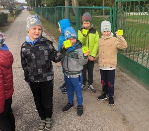 Dzieci prezentują odblaski otrzymane od policjantów.