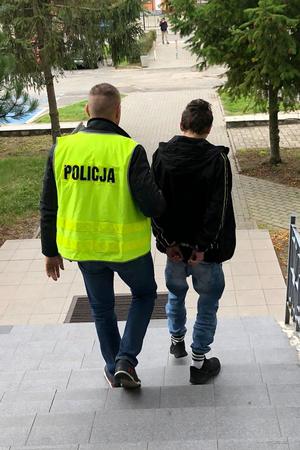 policjant prowadzi poszukiwanego