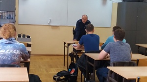 policjant rozmawia z uczniami w klasie