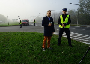 Wywiad z policjantem ruchu drogowego podczas działań. W tle patrol zatrzymujący pojazd do kontroli.