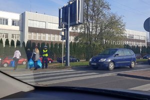 policjant obserwuje ruch pieszych na przejściu dla pieszych