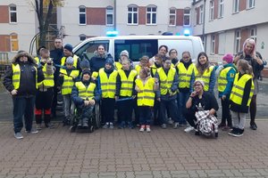 Zdjęcie grupowe uczestników spotkania na tle budynku szkoły.