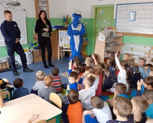 Policjanci prowadzą zajęcia z uczniami. Towarzyszy im policyjna maskotka.