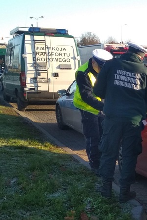 policjant i inspektor ITD kontrolują pojazd oraz kierowcę