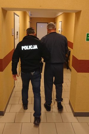 policjant prowadzi zatrzymanego