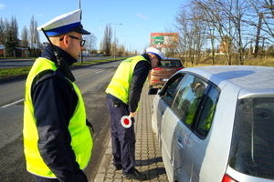 Policjant przy zatrzymanym do kontroli pojeździe.