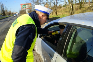 Policjant bada kierującego pod kątem trzeźwości.