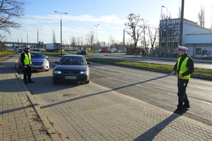 Policjanci podczas zatrzymania pojazdu do kontroli drogowej.