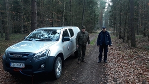 Funkcjonariusze podczas patrolu pieszego terenów leśnych.