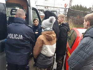 Policjantka ruchu drogowego opowiada o pracy przy jednym z radiowozów.