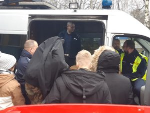 Uczniowie oglądają radiowóz wypadkowy ruchu drogowego słuchając przy tym prelekcji policjanta.