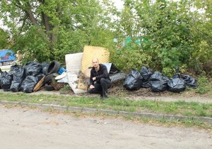 Policjant kuca przy zebranych śmieciach