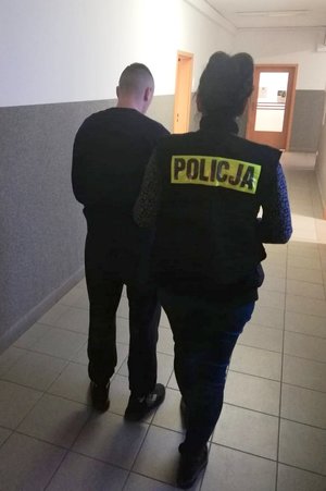 policjantka prowadzi zatrzymanego