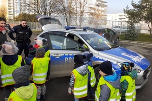 policjant pokazuje dzieciom policyjny radiowóz